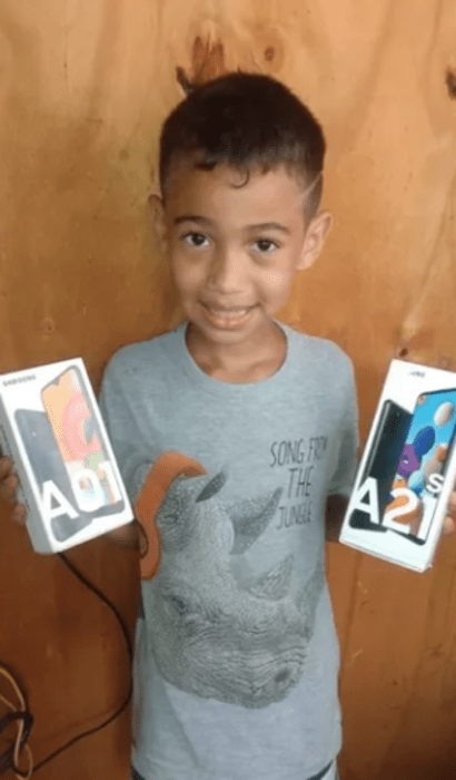 Niño sujetando en sus manos dos celulares que le regalaron en redes sociales 