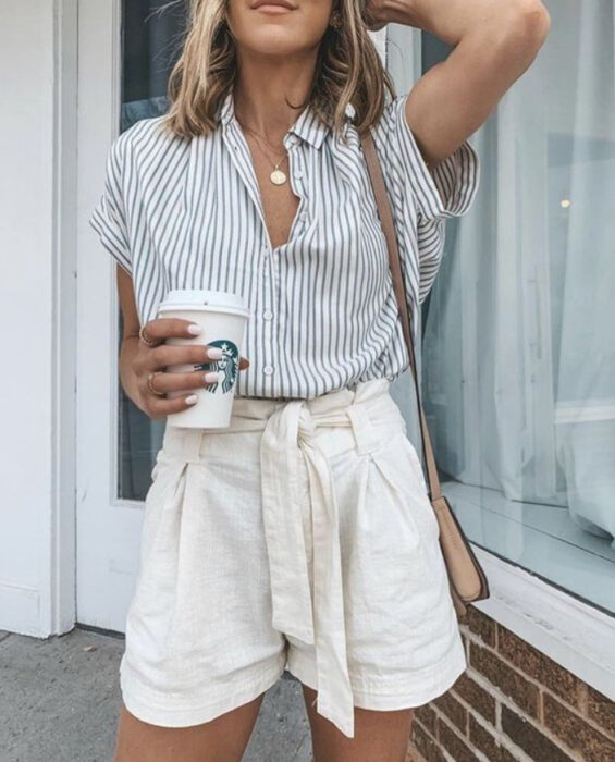 Chica usando camisa de color blanco con rayas azules y short blanco