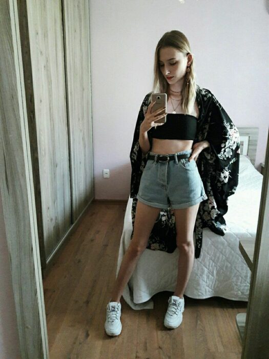 Chica usando unos mom shorts acompañados de un kimono con top negro 