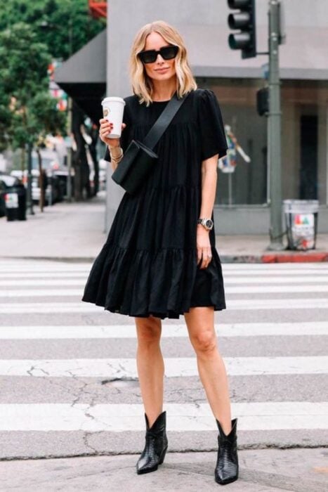 Chica usando un vestido de color negro con botas vaqueras