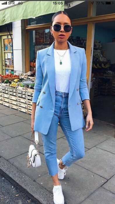 Chica usando un outfit totalmente azul con tenis y bolso blanco