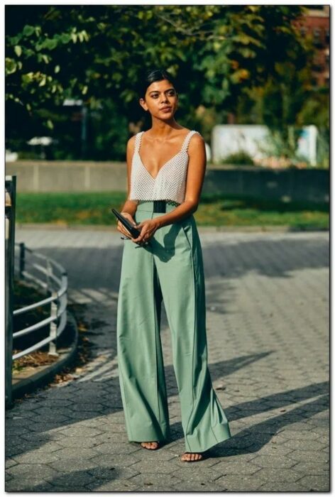 Chica usando unos pantalones de color verde con top de color gris 