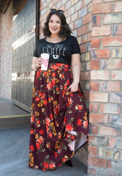 Chica usando una falda larga con un top de color negro mientras posa para una foto 