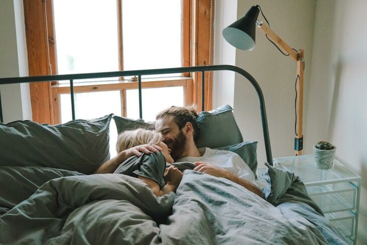 Pareja recostada en la cama