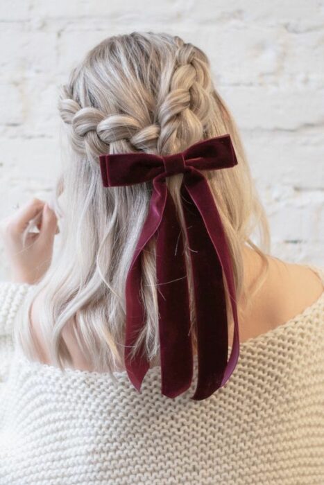 Chica con dos trenzas decorado con moño color guinda