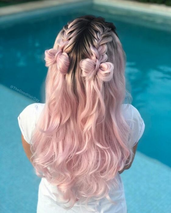 Chica de cabello rosa bebé, con trenzas que terminan en moñitos