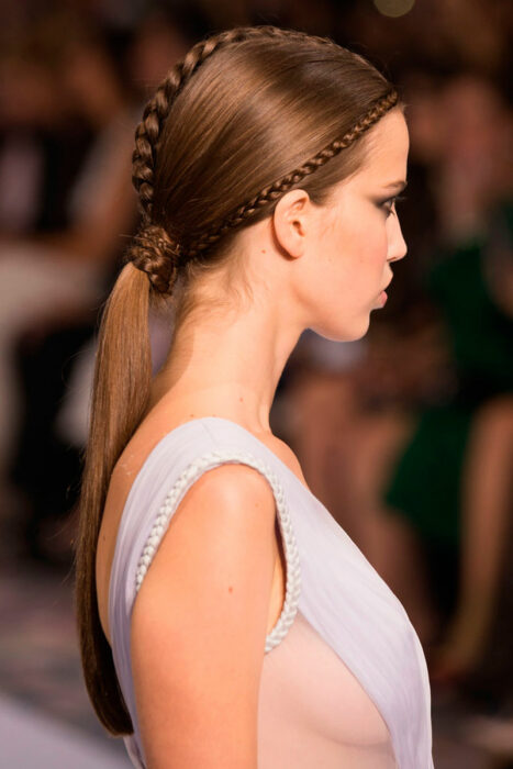 Chica con una coleta baja acompañada de trenzas 