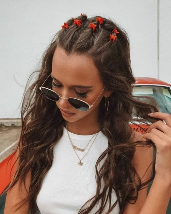 Chica llevando torcidos sobre el cabello con pinzas de mariposa; Peinados de los 90 que están de regreso 
