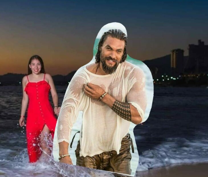 Edición de Jason Momoa en la foto de una pareja que camina por la playa