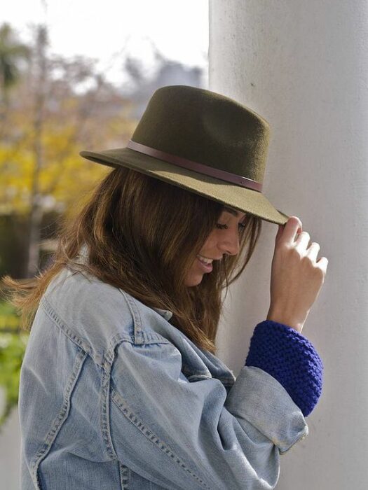 Chica usando chaqueta de mezclilla y sombrero boho color verde