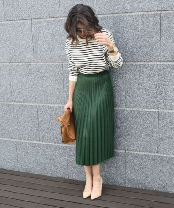 Chica usando tacones, blusa de rayas blanco y negro y maxi falda color verde