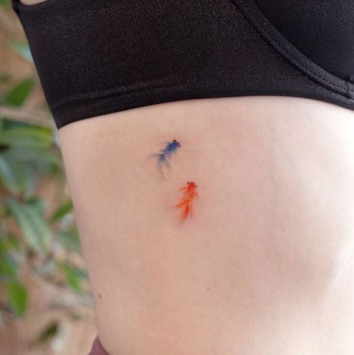 Tatuaje de peces en el costado del abdomen