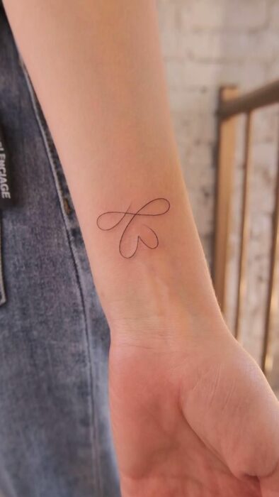 Tatuaje de corazón e infinito en la muñeca