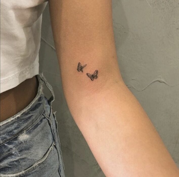 Chica con un tatuaje en la mano en forma de marriposa 