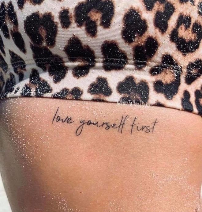 Chica con un tatuaje con la frase love yourself first