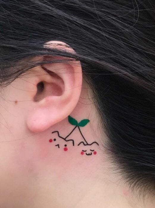 Tatuaje simulando cerezas con hojitas verdes; Tatuajes con diseños kawaii para niñas bien