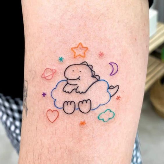 Tatuaje de líneas finas simulando un dinosaurio sentado en una nube; Tatuajes con diseños kawaii para niñas bien