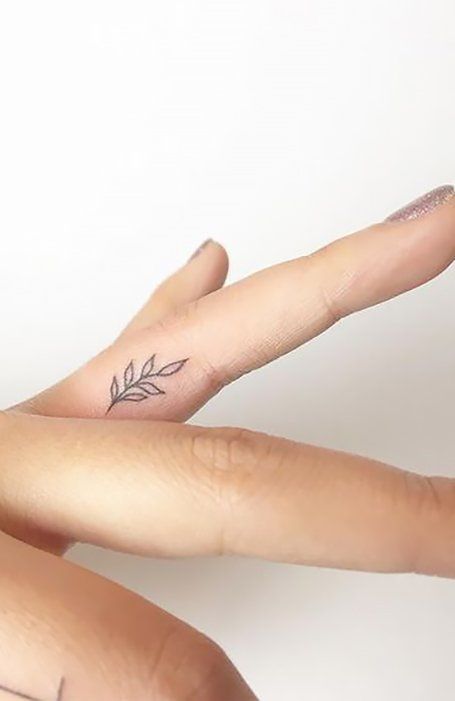 Chica con un tatuaje en forma de flores en el dedo medio 