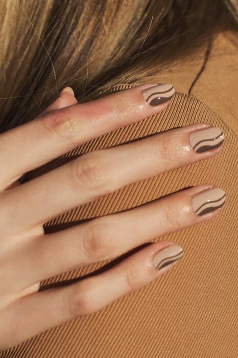 Manicura en tonos café y beige con líneas