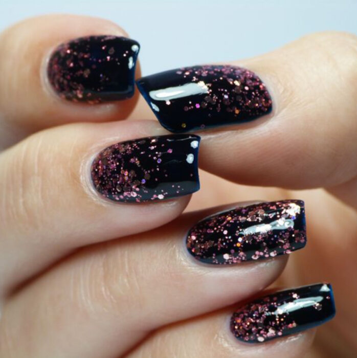 Manicura con fondo negro con destellos de glitter de color cobre