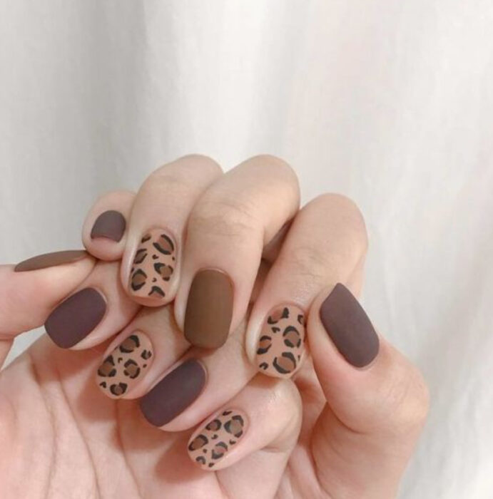 Manicura con diseño en tonos cafés y diseño de animal print