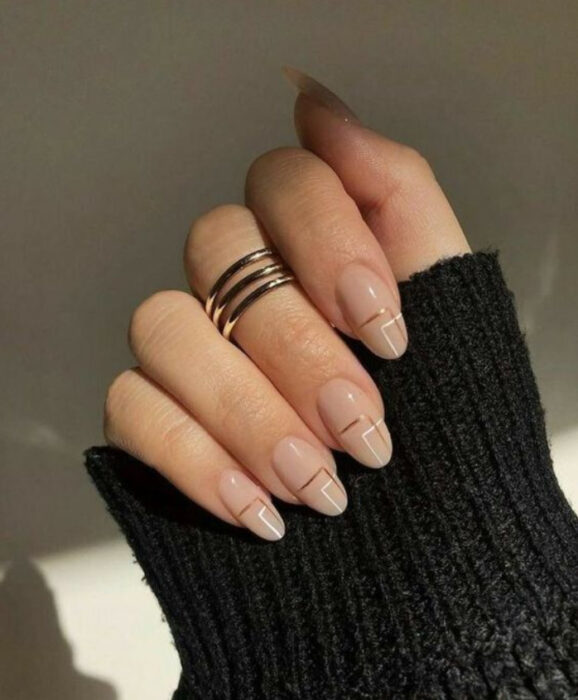 Uñas con base nude y líneas café y blancas