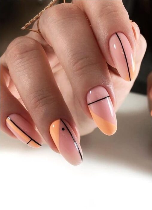 Uñas en color nude, con naranja y líneas negras