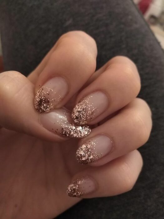 Manicura con fondo nude y detalles de glitter en la punta color dorado