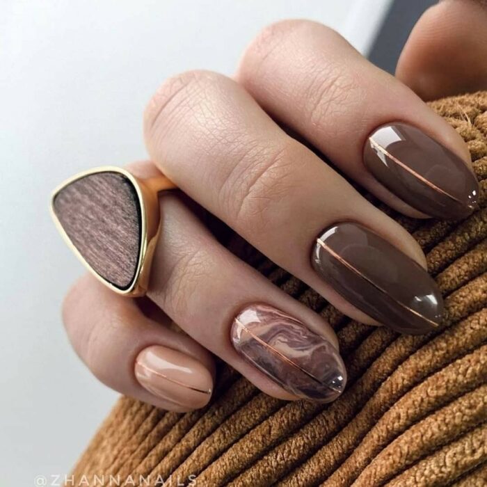 Manicura en tono café con efecto marmol sobre tono beige