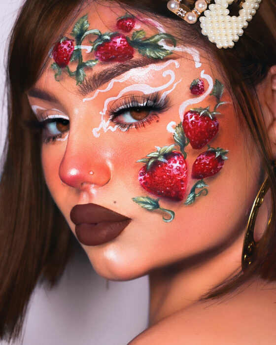 Chica con el rostro pintado con diferentes fresas 