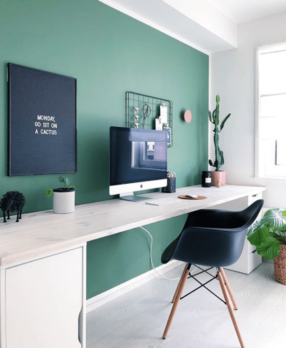 oficina blanca, minimalista con pared verde, silla negra, escritorio blanco y macetas