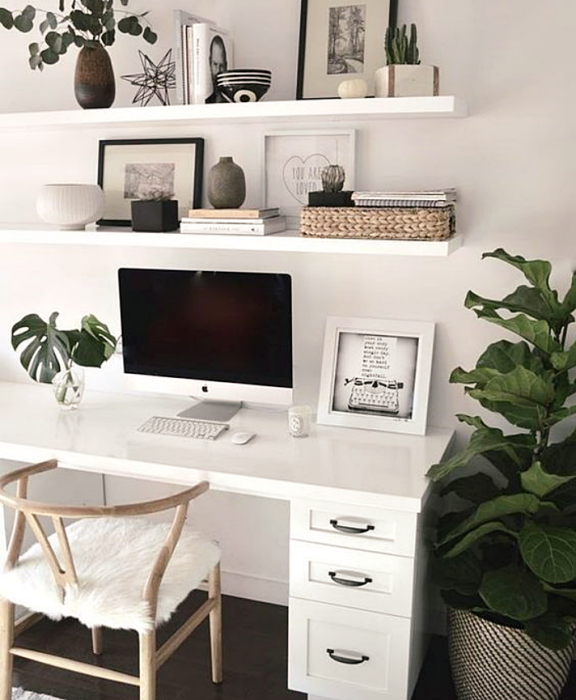 oficina blanca, minimalista, monocromática con escritorio y repisas blancas, silla metálica, computadora y macetas