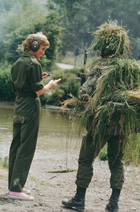 Lady di usando un traje militar con unos tenis converse de color rosa 