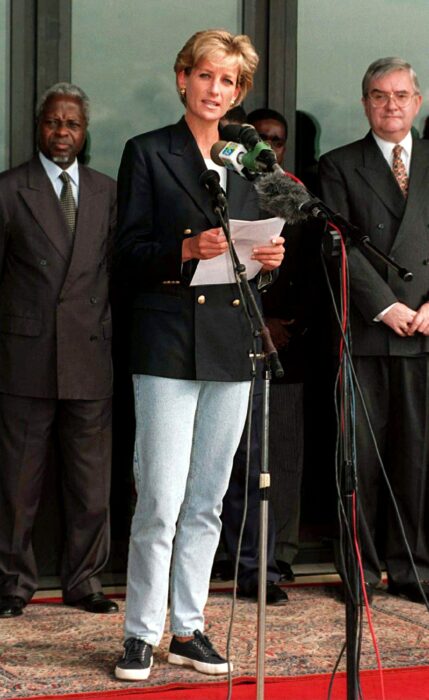 Diana Spencer dando un discurso en Angola mientras usa jeans, tenis y una chaqueta 