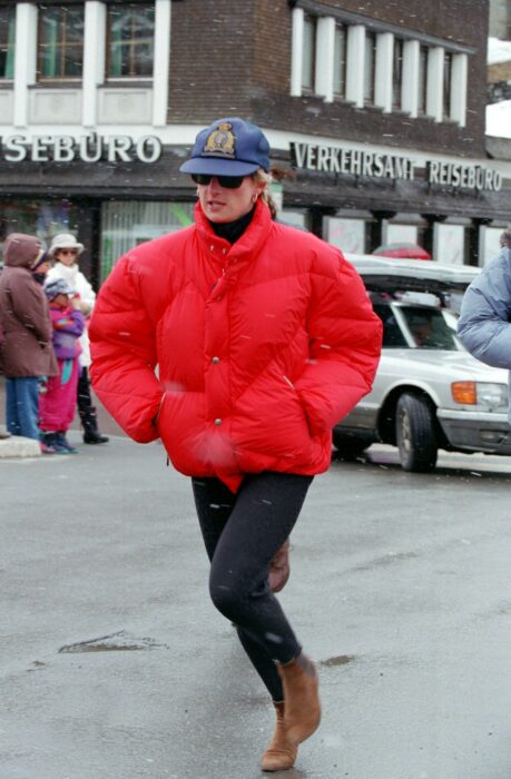 Diana spencer usando una puffer Jacket en color roja con una gorra 