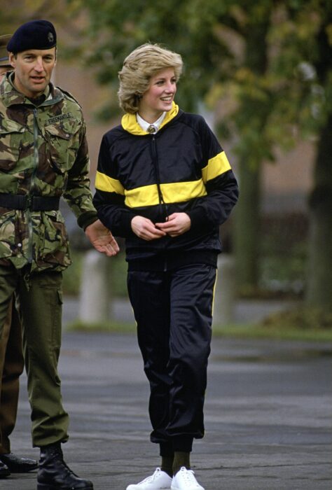 Diana Spencer usando un conjunto deportivo en color negro con amarillo