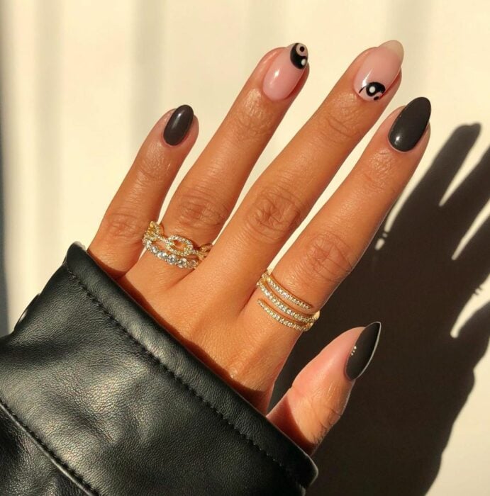 Chica mostrando sus uñas con diseño Yin Yang en color nude con negro 