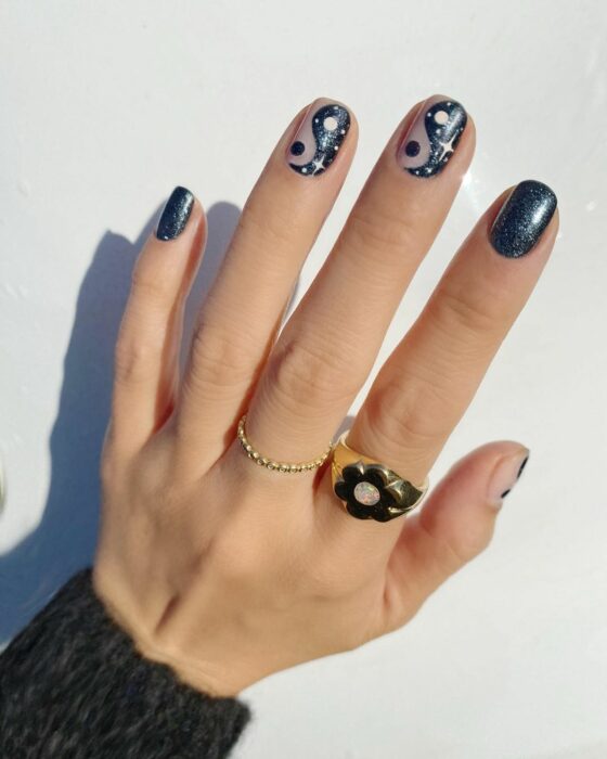 Chica mostrando sus uñas con diseño Yin Yang en color gris con azul 