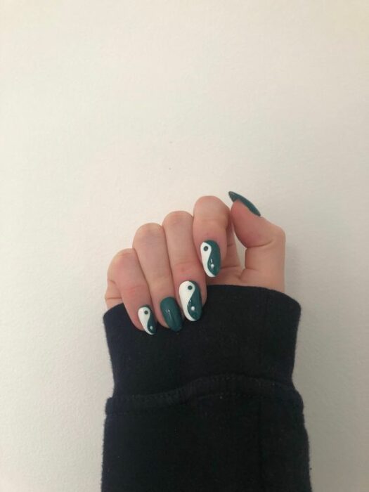 Chica mostrando sus uñas con diseño Yin Yang en color verde con blanco 