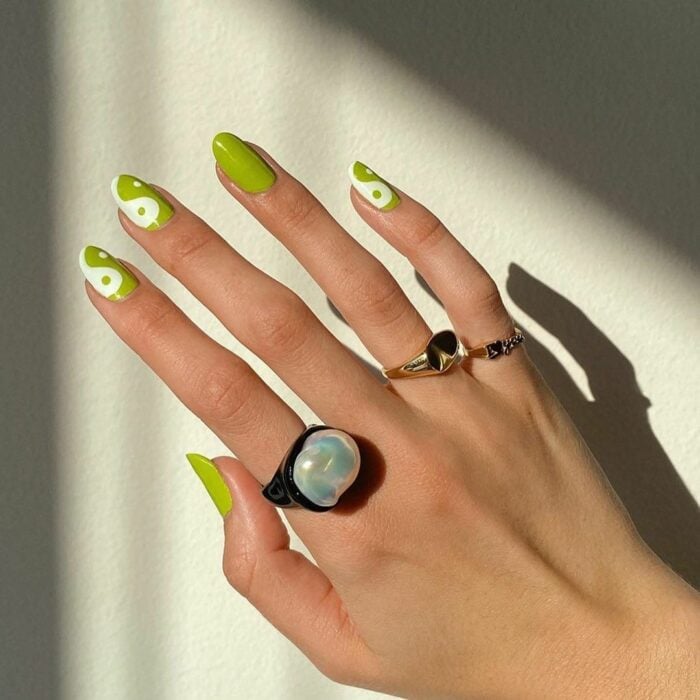 Chica mostrando sus uñas con diseño Yin Yang en color verde con blanco 