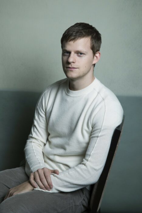 Lucas Hedges sentado en una silla; 15 Celebridades menores de 30 que son las futuras promesas de Hollywood