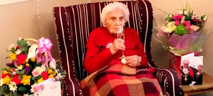 Abuelita bebiendo una copa de vino tinto para celebrar su cumpleaños 105