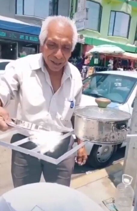 Abuelito de 71 años mostrando cómo funciona su estufa solar 