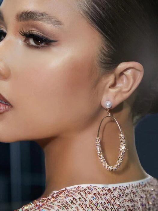 Chica usando unos aretes redondos con brillantes 