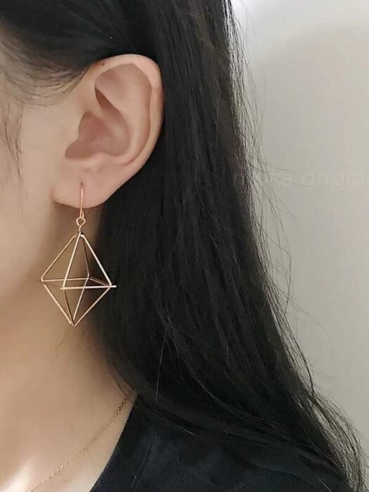 Chica usando unos aretes en forma de rombo