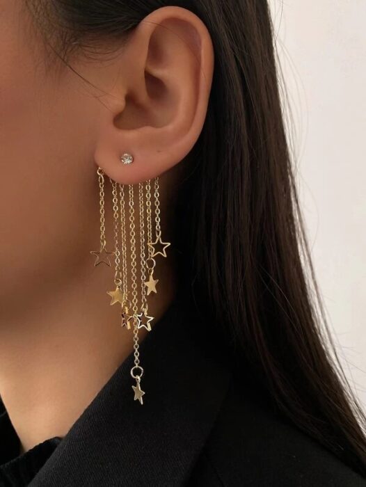 Chica usando unos aretes en forma de constelación de estrellas 