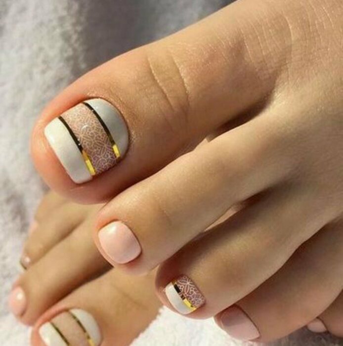 Diseño de uñas para pies en color  blanco con líneas doradas y blancas 