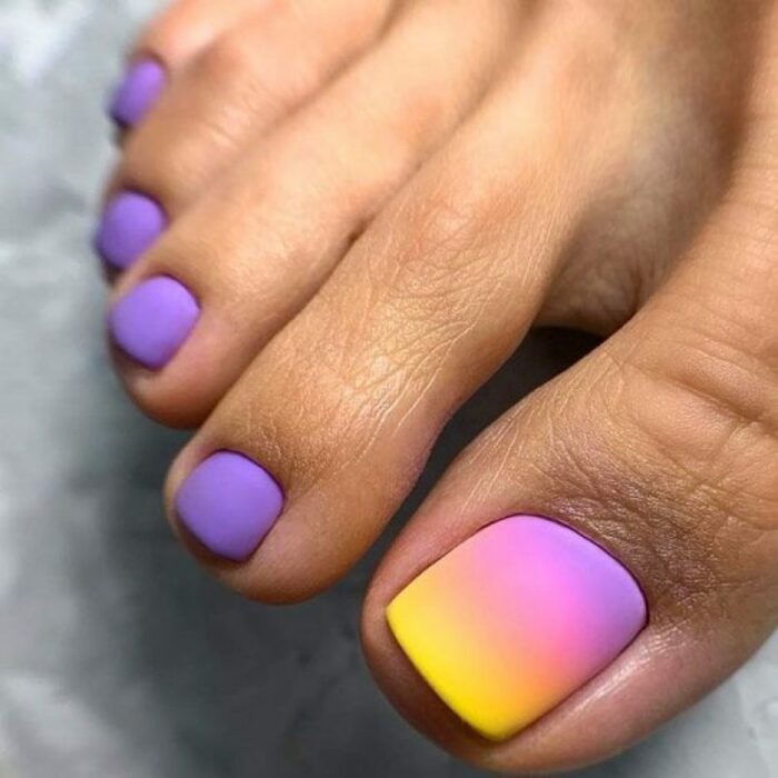 Diseño de uñas para pies en colores morado con amarillo y rosa 