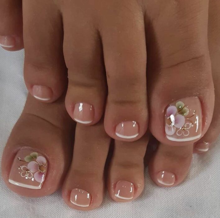 Diseño de uñas para pies en estilo french con flores 