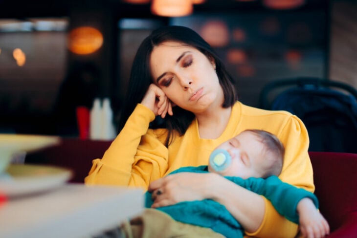 Mamá quedando dormida mientras carga a su bebés; Las mamás son las que menos duermen en la casa